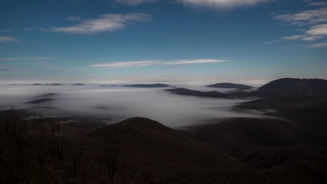 4K timelapse Inversely clouds in the mountain landscape at night at the end of the month