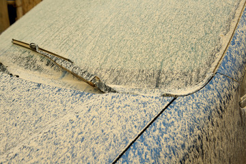Ancient car windshield rendered opaque by sand and dust.