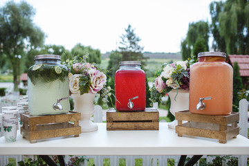Fresh fruit juice jars on a white table.