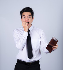 Portrait handsome young asian .businessman wearing a white shirt stressed because empty wallet no money isolated on grey background in studio. Asian man people. business success concept.