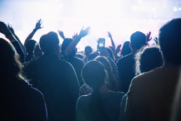 Silhouette of a crowd of fans at a concert.