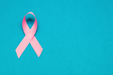 Pink ribbon for breast cancer awareness, symbolic bow color raising awareness on people living with women's breast tumor illness. bow isolated with clipping blue background