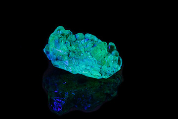 macro mineral stone opal under ultraviolet light on a black background