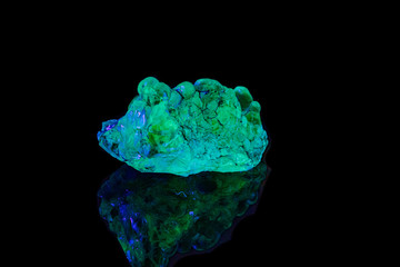 macro mineral stone opal under ultraviolet light on a black background