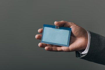 Cropped view of man holding badge isolated on grey