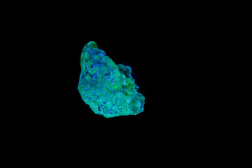 macro mineral stone opal under ultraviolet light on a black background