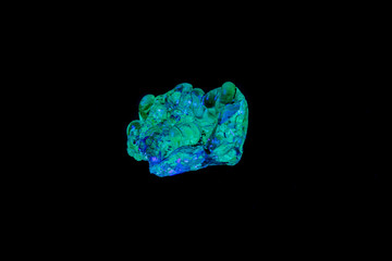 Fototapeta premium macro mineral stone opal under ultraviolet light on a black background