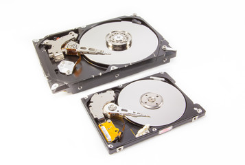 Two different size hard drives showing interior over white background