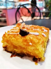 Delicious sweet orange cake, traditional greek pastry baked with orange pieces and honey, served in white plate.