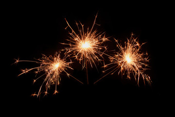 Fototapeta premium Three sparklers firework on black background. Christmas celebration.