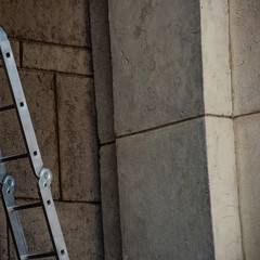 Metal folding staircase at the stone building