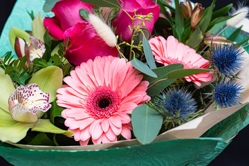 Beautiful fresh flowers in a bouquet close-up, orchids, gerberas, roses. Concept of nature.