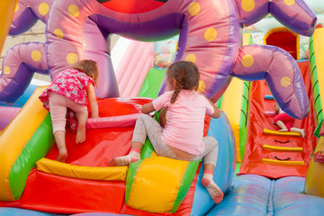 A cheerful child plays in an inflatable castle - obrazy, fototapety, plakaty