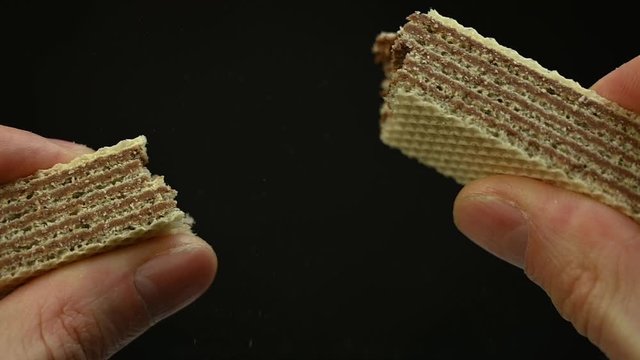 man hands breaks biscuit waffle cookies