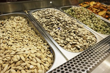 Selection of nuts on display in shop in stainless steel containers