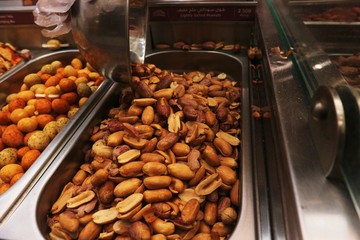 Selection of nuts on display in shop in stainless steel containers