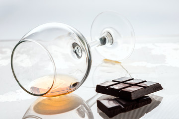 still life of a glass glass with alcohol and chocolate bars.