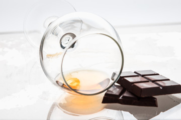 still life of a glass glass with alcohol and chocolate bars.