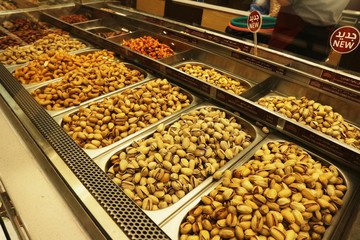 Selection of nuts on display in shop in stainless steel containers