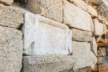 A marble  slab with an inscription in Latin on the ruins of a Roman aqueduct near Caesarea in northern Israel