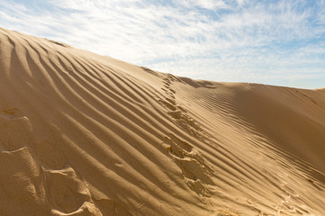 Footprints  of a man rising up a sand dune near the ruins of the Roman aqueduct in Caesarea, in northern Israel