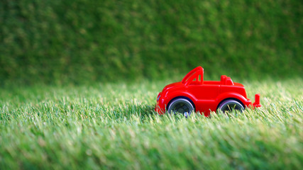 Toy car on the green artificial grass. Artificial turf background with copy space.