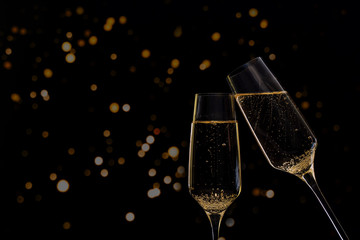 Glasses of champagne on black background with lights