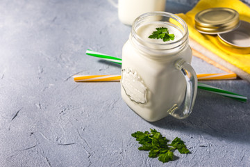 simple homemade kefir in a glass with spices and herbs on a gray background, copy space. Probiotic Ayran