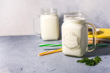 simple homemade kefir in a glass with spices and herbs on a gray background, copy space. Probiotic Ayran
