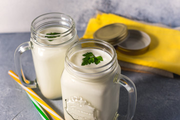 simple homemade kefir in a glass with spices and herbs on a gray background, copy space. Probiotic Ayran