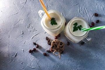 simple homemade kefir in a glass with spices and herbs on a gray background, copy space. Probiotic Ayran
