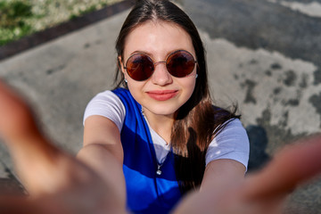 teen girl in round sunglasses makes selfie