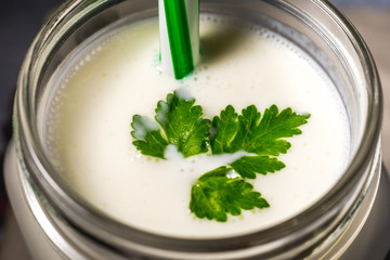 simple homemade kefir in a glass with spices and herbs on a gray background, copy space. Probiotic Ayran