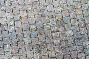 An old stoneblock pavement cobbled with square stone blocks