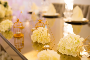 Beautiful golden decoration, flowers and candles on a table.