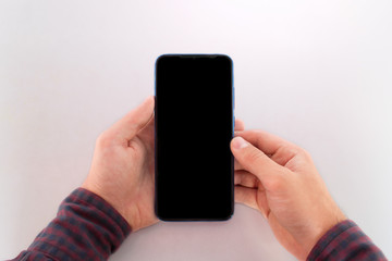 holding a mobile phone with a blank black screen. reads from a smartphone mockup