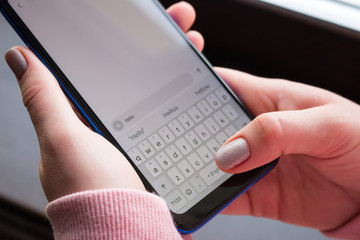 holding a smartphone close-up, writing a message