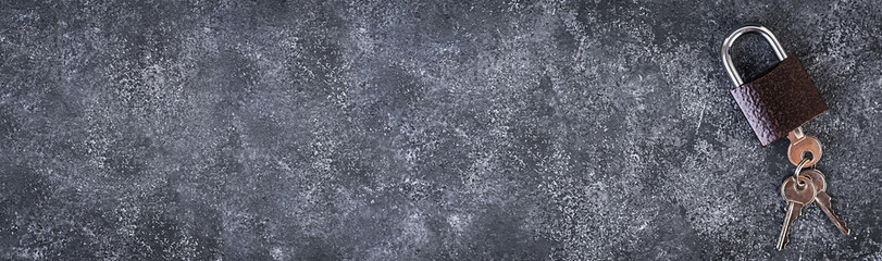 Iron lock with keys on grey background. Top view. Banner