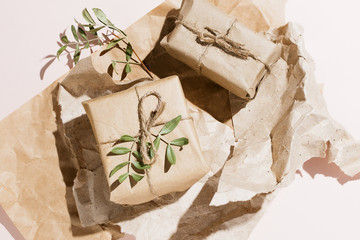 Minimalist flat lay of eco-friendly gift box wrapped in craft paper with pistachio branches