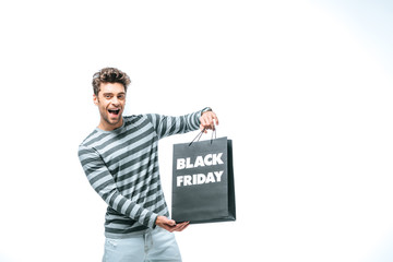 excited man holding shopping bag on black friday, isolated on white