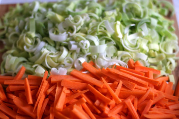 Chopped carrots and leek on a cutting board. Selective focus.