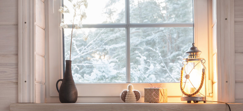 Beautiful burning candles and fairy lights on windowsill indoors