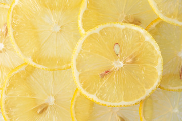 Close-up yellow lemon cross section slices pattern, top view. Fresh juicy food concept