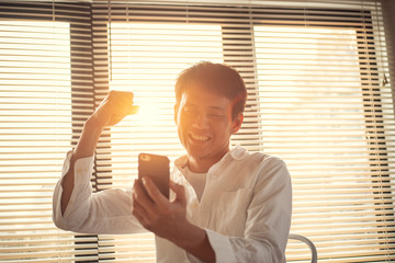 Businessman happy after recieve good news to get a new job from smartphone