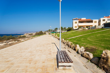 Bench on the promenade along the Mediterranean coast with Hotels.