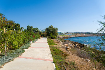 Bench on the promenade along the Mediterranean coast with Hotels.