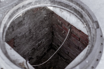 Open sewage system. Descent into the sewer with brick walls