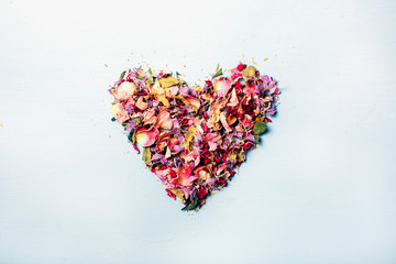 Composition of dried flowers in the shape of a heart on a white background, concept of love