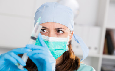 Professional nurse young woman making injection in hospital