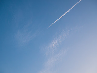 Blue sky with white trail of cloud from airplane. 